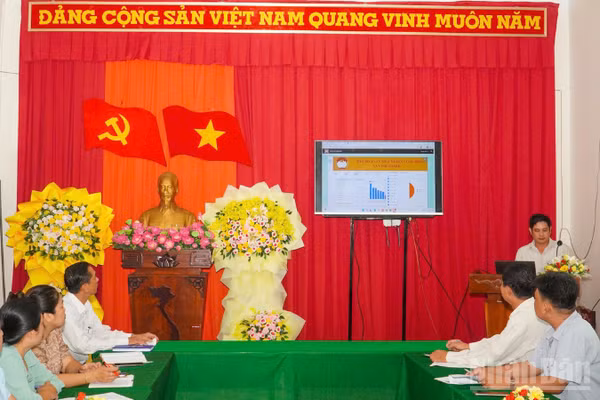 Lãnh đạo Ủy ban Mặt trận Tổ quốc Việt Nam xã Vĩnh Thạnh trao đổi, quan sát việc ứng dụng dữ liệu số trong công tác an sinh và giảm nghèo bền vững. (Ảnh VĂN ÚT)