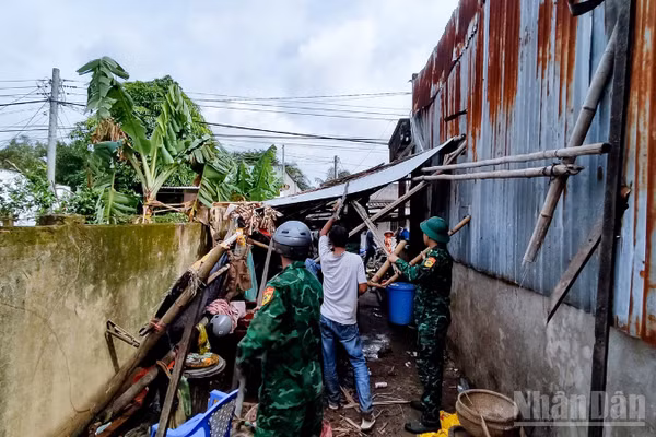 Cán bộ, chiến sĩ đồn Biên phòng Lai Hòa, Bộ đội Biên phòng thành phố Cần Thơ giúp dân khắc phục hậu quả lốc xoáy. (Ảnh: VĂN LONG)