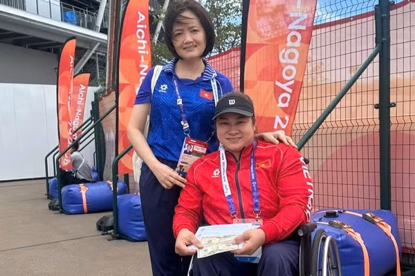 Đại diện Đoàn Thể thao người khuyết tật Việt Nam trao thưởng cho vận động viên Nguyễn Thị Ngọc Thúy sau khi giành Huy chương Đồng nội dung ném đĩa nữ hạng thương tật F54 tại Asian Para Games 5 ở Nagoya, Nhật Bản. (Ảnh: THU HOÀI)