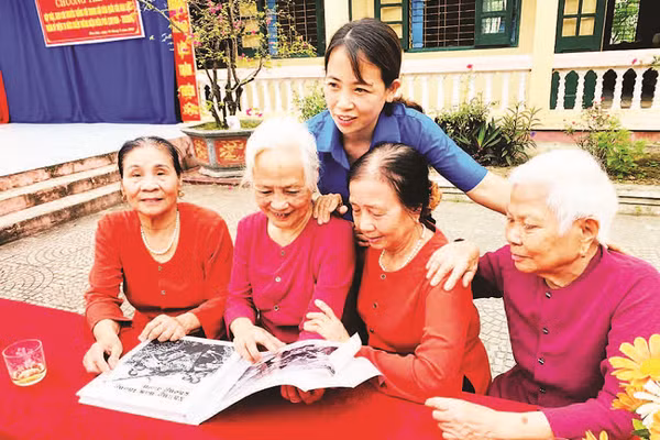Các cựu nữ dân quân lật giở những hình ảnh tư liệu quý về Trung đội dân quân gái Hoa Lộc.