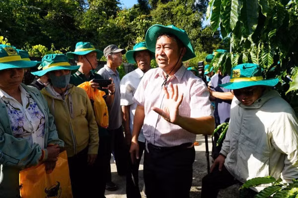 Chuyên gia chương trình trao đổi kỹ thuật với nông dân tại vườn mô hình. (Ảnh: HỒ HUY)