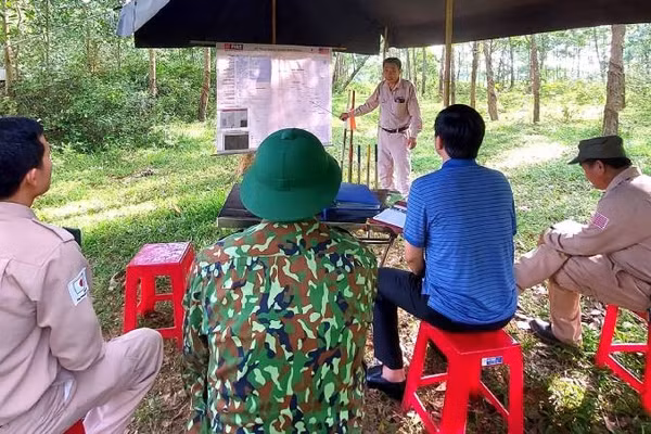 Nhân viên của Dự án MAG giới thiệu về hiện trường trước khi tiến hành dò tìm và xử lý vật nổ giữa rừng cao-su ở phía bắc Quảng Trị (Ảnh: HƯƠNG GIANG)