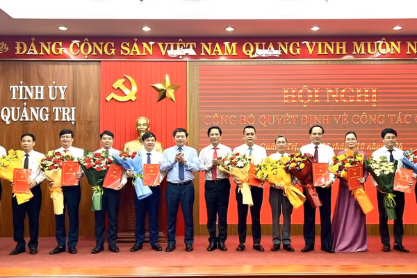 Các đồng chí lãnh đạo tỉnh Quảng Trị trao quyết định và tặng hoa các cán bộ được điều động, phân công, chỉ định nhiệm vụ. (Ảnh: HG)