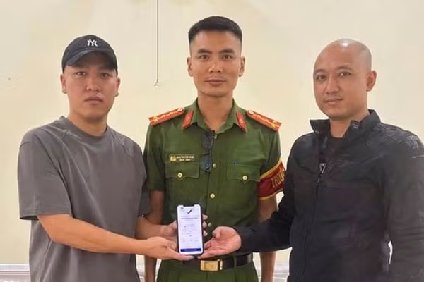 Anh Hoàng Quốc Cường (bên trái) trả lại 5 tỷ đồng chuyển khoản nhầm cho anh Quân trước sự chứng kiến của đại diện Công an xã Hoàn Lão. (Ảnh: Công an xã Hoàn Lão)