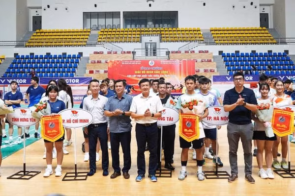 Các đại biểu tặng cờ lưu niệm và hoa cho đại diện các đoàn vận động viên (Ảnh: HG)