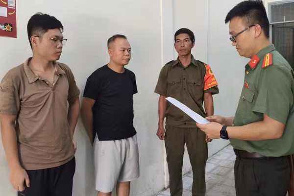 Cơ quan An ninh điều tra Công an thành phố tống đạt các quyết định đối với Chu Đức Anh và Nguyễn Trung Hiếu. (Ảnh: Công an cung cấp)