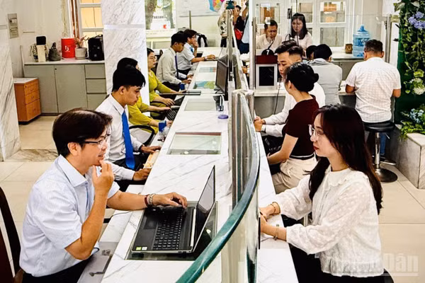 Công chức Trung tâm Phục vụ hành chính công phường Sài Gòn tiếp nhận và giải quyết thủ tục hành chính cho người dân. (Ảnh: VƯƠNG LÊ)