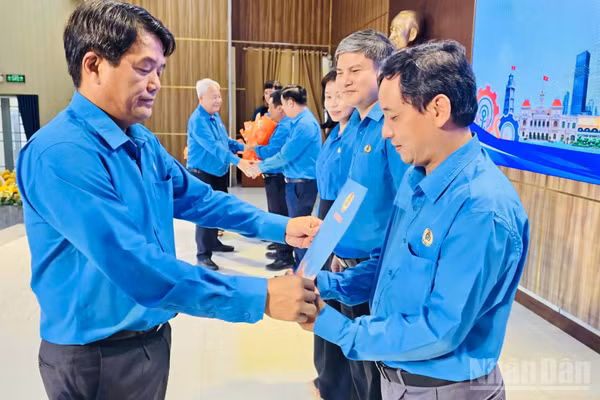Ông Bùi Thanh Nhân, Chủ tịch Liên đoàn Lao động Thành phố Hồ Chí Minh trao quyết định thành lập các Công đoàn khu công nghiệp cho các cán bộ công đoàn. (Ảnh: VƯƠNG LÊ) 