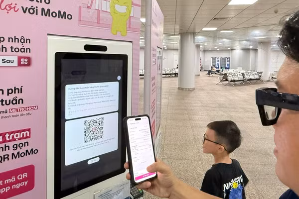 Hành khách thanh toán trực tuyến để mua vé đi Metro. (Ảnh: QUÝ HIỀN)