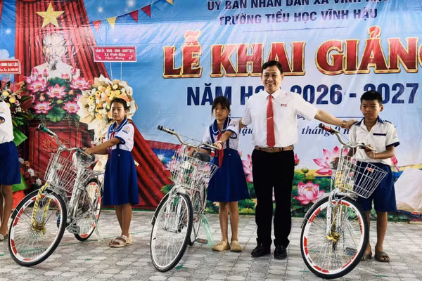 Đồng chí Trần Hoàng Khải, Chủ tịch Ủy ban nhân dân xã Vĩnh Hậu (Cà Mau), trao tặng xe đạp cho các em học sinh nghèo vùng ven biển, học sinh dân tộc Khmer trong xã. (Ảnh: ĐẶNG THẾ VĨNH)