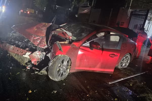 Chiếc xe ô-tô Mazda 6 sau khi tông sập cổng nhà dân bị hư hỏng nặng phần đầu. (Ảnh: CTV)