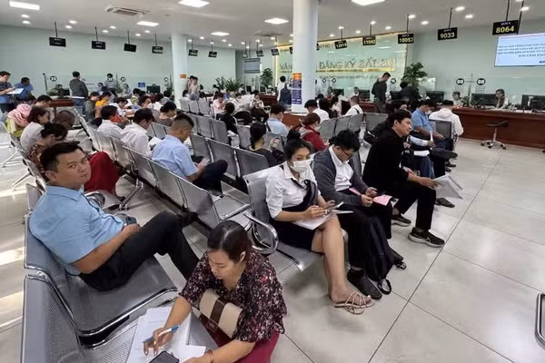 Người dân thực hiện thủ tục hành chính tại Văn phòng Đăng ký đất đai. (Ảnh: QUANG QUÝ)