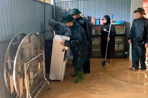 Cán bộ, chiến sĩ Đồn Biên phòng Nhôn Mai hỗ trợ người dân di dời tài sản. (Ảnh: LÊ THẠCH)