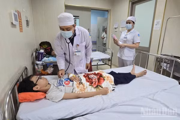 Bác sĩ của Bệnh viện Sản nhi tỉnh khám, điều trị 1 ca mắc bệnh sốt xuất huyết. (Ảnh: THANH DŨNG)