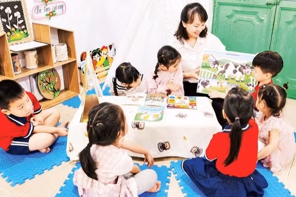 Cô và trò làm quen với sách trước năm học thí điểm Chương trình giáo dục mầm non mới. (Ảnh: THU TRANG)