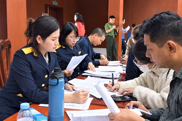 Cán bộ thuế hỗ trợ người dân thực hiện các thủ tục về thuế. (Ảnh: TNA)