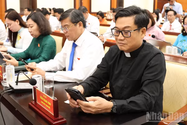 Các đại biểu nhấn nút thông qua Đề án thành lập các phường trên cơ sở nguyên trạng 29 xã trên địa bàn thành phố. (Ảnh: THẾ ANH)