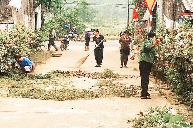 Người dân xã Suối Hai cùng nhau làm sạch đường làng ngõ xóm (Ảnh HỒNG LÊ)
