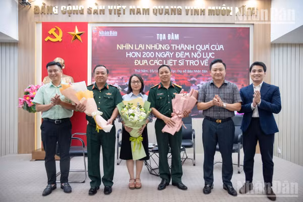 Đồng chí Phan Văn Hùng, Phó Tổng Biên tập Báo Nhân Dân tặng hoa cho các khách mời tham dự tọa đàm trực tuyến “Nhìn lại những thành quả của hơn 200 ngày đêm nỗ lực đưa các liệt sĩ trở về”. Ảnh: MINH DUY.