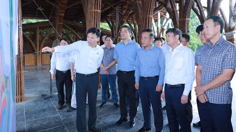 Các thành viên đoàn công tác nghe báo cáo về tình hình thực hiện Dự án Công viên sinh thái tre luồng Tam Thanh.
