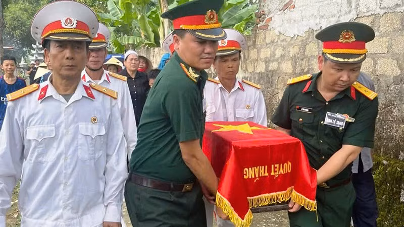 Lực lượng vũ trang cùng các cựu chiến binh di chuyển hài cốt liệt sĩ.