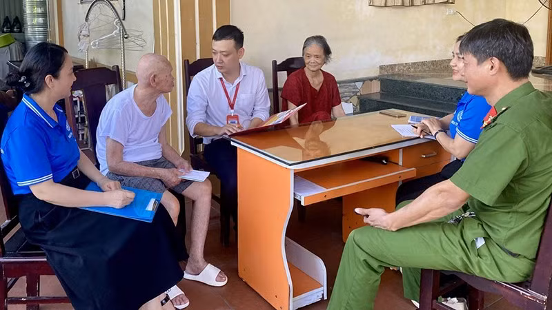 Lực lượng chức năng tiếp cận tuyên truyền, hướng dẫn người cao tuổi nhận chính sách qua tài khoản ngân hàng.