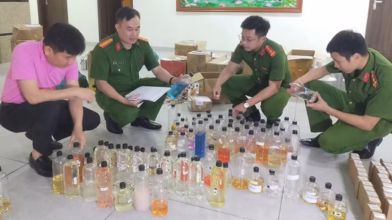 Công an xem xét các loại hương liệu mà các đối tượng đã sử dụng sản xuất nước hoa giả.