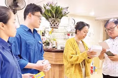 Thành viên tổ công nghệ số cộng đồng của phường Hồng Bàng hướng dẫn người dân sử dụng những tiện ích số (Ảnh HUY VŨ)