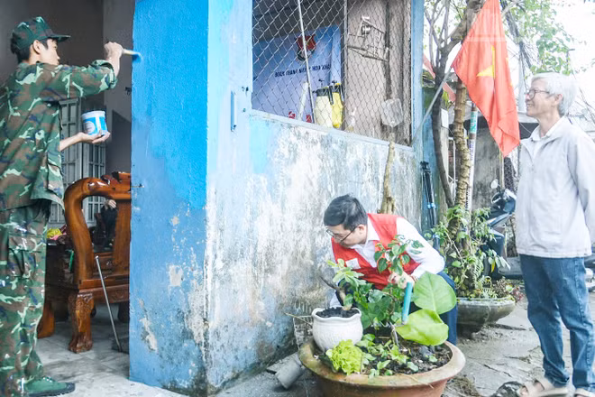 Ông Lê Văn Nam (bên phải) vui mừng khi ngôi nhà được các tình nguyện viên hỗ trợ sơn mới.