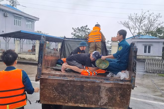 Lực lượng chức năng xã Điện Bàn Tây vận chuyển người bị nạn qua vùng ngập lũ để đi cấp cứu.