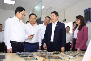 Phó Thủ tướng Hồ Quốc Dũng (bên trái ảnh) tham quan phòng thí nghiệm vi mạch tại Trường đại học Bách khoa, Đại học Quốc gia Thành phố Hồ Chí Minh. (Ảnh: MỘC MIÊN)