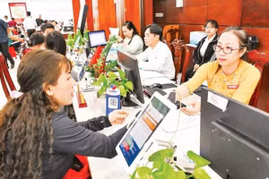 Người dân làm thủ tục hành chính tại xã Tân Nhựt (Ảnh THẾ ANH).