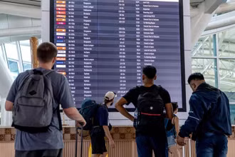 Hành khách xem thông tin trên bảng điện tử tại sân bay quốc tế I Gusti Ngurah Rai ở Bali, Indonesia. (Ảnh: XINHUA)
