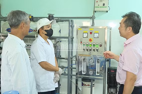 Anh Trần Văn Được bên cơ sở sản xuất nước tinh khiết của gia đình. (Ảnh: KIỀU DUYÊN)