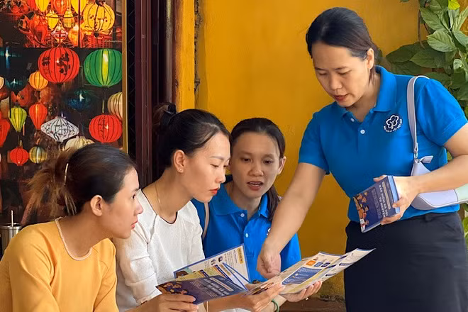 Cán bộ Bảo hiểm xã hội tuyên truyền chính sách bảo hiểm xã hội, bảo hiểm y tế cho người lao động phường Hội An (thành phố Đà Nẵng).