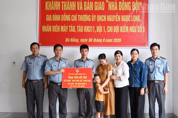Đồng chí Vũ Thành Long, cán bộ Chi đội Kiểm ngư số 3 (thứ hai từ trái sang) trao kinh phí hỗ trợ nhà đồng đội cho gia đình đồng chí Nguyễn Ngọc Long. (Ảnh: NGUYỄN DŨNG)
