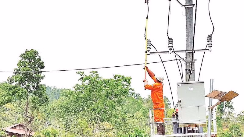 Người dân Tia Ma Mủ chứng kiến công nhân Công ty Điện lực Lai Châu làm thủ tục đóng và cấp điện cho bản.