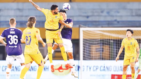 Pha tranh bóng giữa cầu thủ Hà Nội FC và Sông Lam Nghệ An (áo vàng). (Ảnh: VPF)