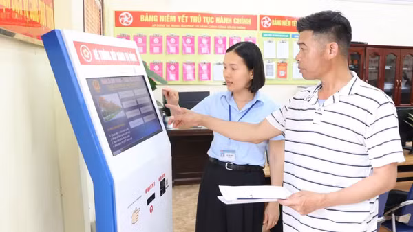 Công chức Trung tâm Phục vụ hành chính công xã Kim Thành, thành phố Hải Phòng, hướng dẫn người dân làm thủ tục hành chính. (Ảnh: TTXVN) 