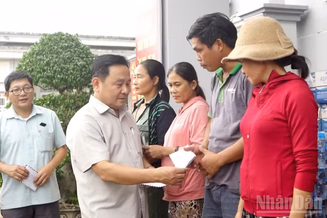 Phó Chủ tịch Hội đồng nhân dân thành phố Đà Nẵng Nguyễn Công Thanh tặng quà cho các hộ dân ở xã Quế Phước bị thiệt hại nặng do mưa lũ gây ra.