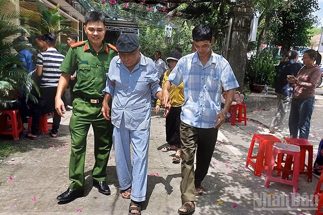 Cán bộ, chiến sĩ Công an xã Phú Ninh hỗ trợ người cao tuổi đi làm giấy tờ cá nhân.