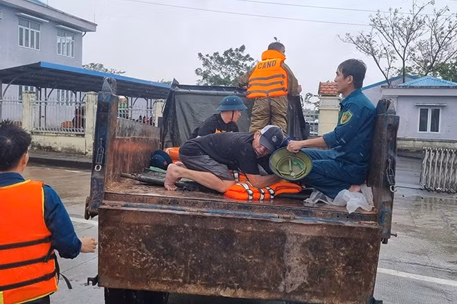 Lực lượng chức năng xã Điện Bàn Tây vận chuyển người bị nạn qua vùng ngập lũ để đi cấp cứu.