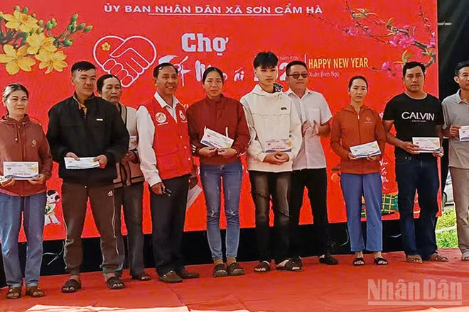 Lãnh đạo xã Sơn Cẩm Hà trao quà cho người dân.