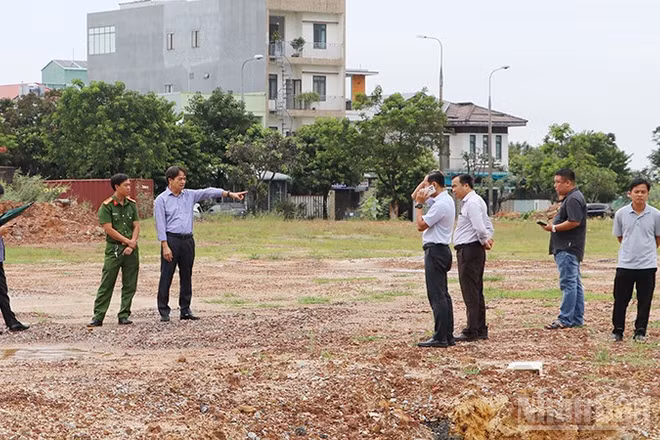 Bí thư Đảng ủy phường Bàn Thạch Nguyễn Duy Ân (chỉ tay) kiểm tra thực tế tình trạng đổ chất thải xây dựng tại khu đất ở góc đường Bạch Đằng giao nhau với đường Hồ Nghinh. (Ảnh: QUÂN VẠN)