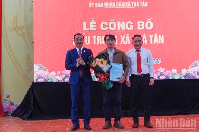 Lãnh đạo xã Trà Tân tặng hoa cho tác giả thiết kế biểu trưng xã Trà Tân.