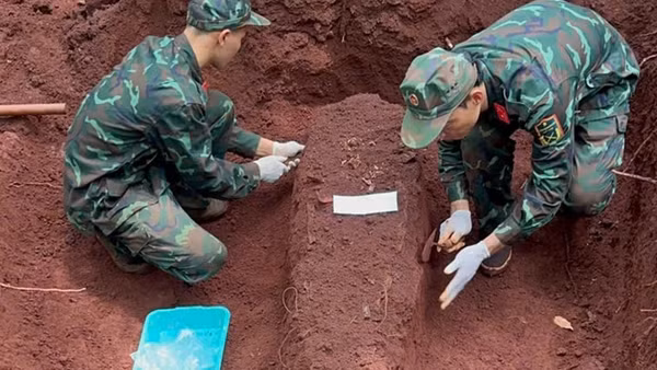Các chiến sĩ Đội K76 cẩn trọng quy tập hài cốt liệt sĩ tại khu vực biên giới thành phố Đồng Nai. (Ảnh: Đội K76)