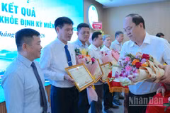 Đồng chí Nguyễn Hồ Hải, Ủy viên Trung ương Đảng, Bí thư Tỉnh ủy Cà Mau (bìa phải) trao tặng hoa và Bằng khen của Chủ tịch Ủy ban nhân dân tỉnh cho các tập thể tiêu biểu, xuất sắc tham gia thực hiện Nghị quyết 72 của Bộ Chính trị tại địa phương. (Ảnh: HỮU TÙNG)