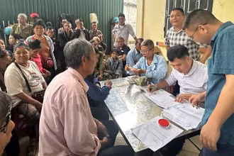 Cán bộ văn phòng Công ty cổ phần Cao-su Điện Biên chi trả tiền góp đất đến người dân trên địa bàn xã Mường Pồn, tỉnh Điện Biên.
