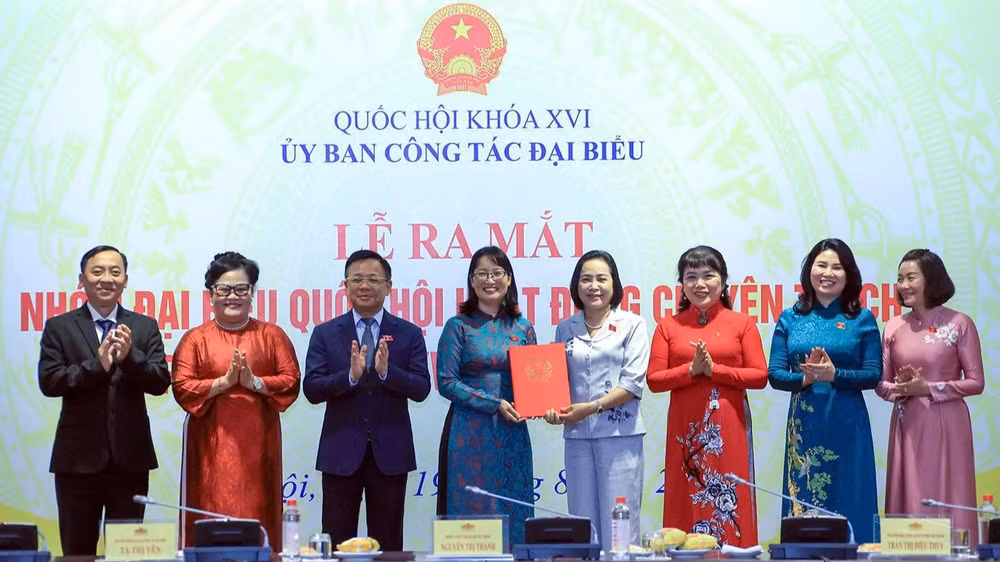 Phó Chủ tịch Quốc hội Nguyễn Thị Thanh trao Nghị quyết của Ủy ban Thường vụ Quốc hội về việc thành lập nhóm đại biểu Quốc hội hoạt động chuyên trách ở địa phương khóa XVI. (Ảnh: TUẤN ANH)