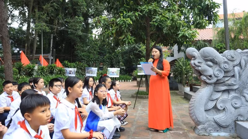 Các em học sinh Trường Tiểu học Xuân La (Hà Nội) học môn Lịch sử địa phương ngay tại di tích đình Quán La (phường Xuân La). (Ảnh: Giang Nam)